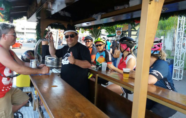 bartender servindo chopp gelado a turistas e ciclistas na oktoberfest em blumenau